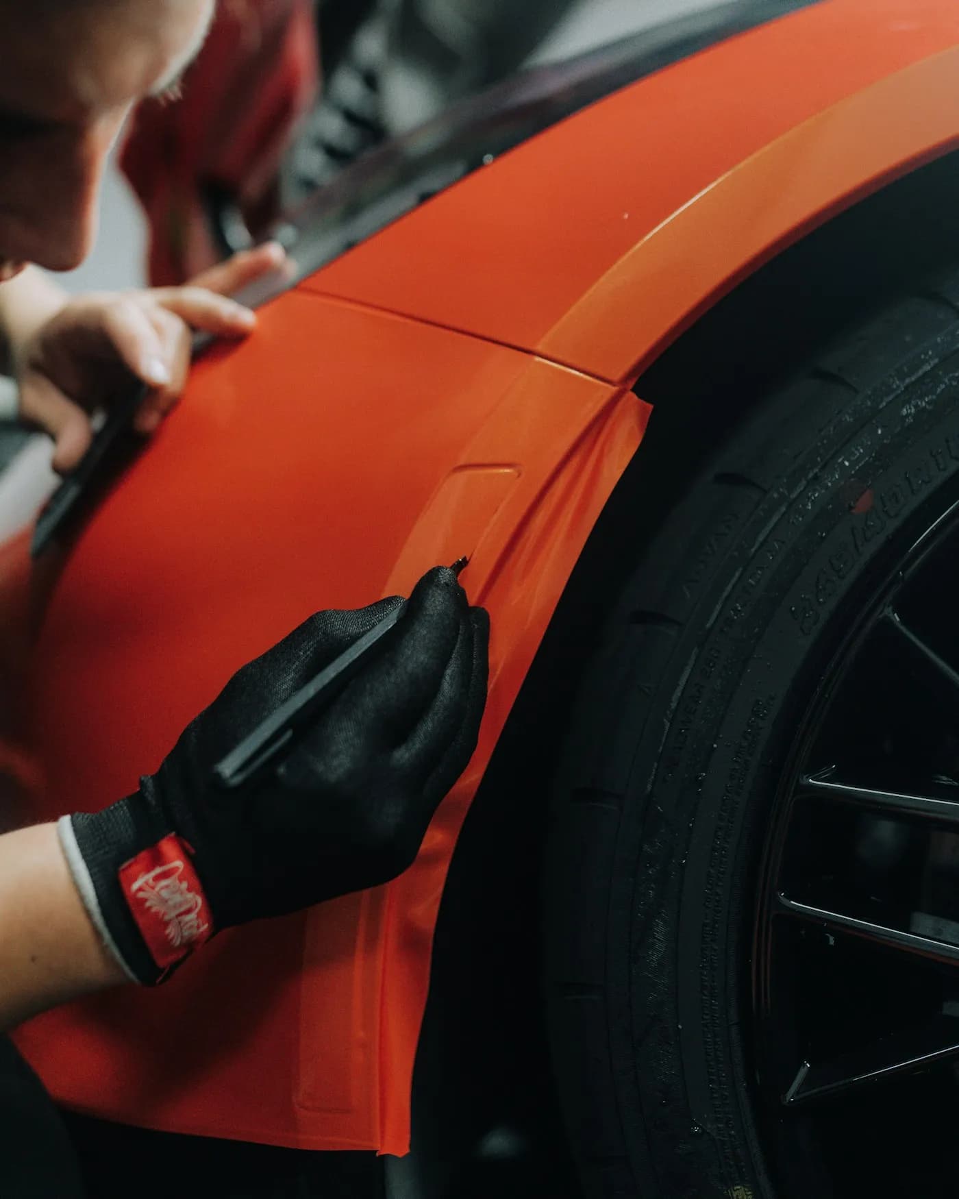 A technician applying custom vinyl lettering to a work vehicle in Ottawa