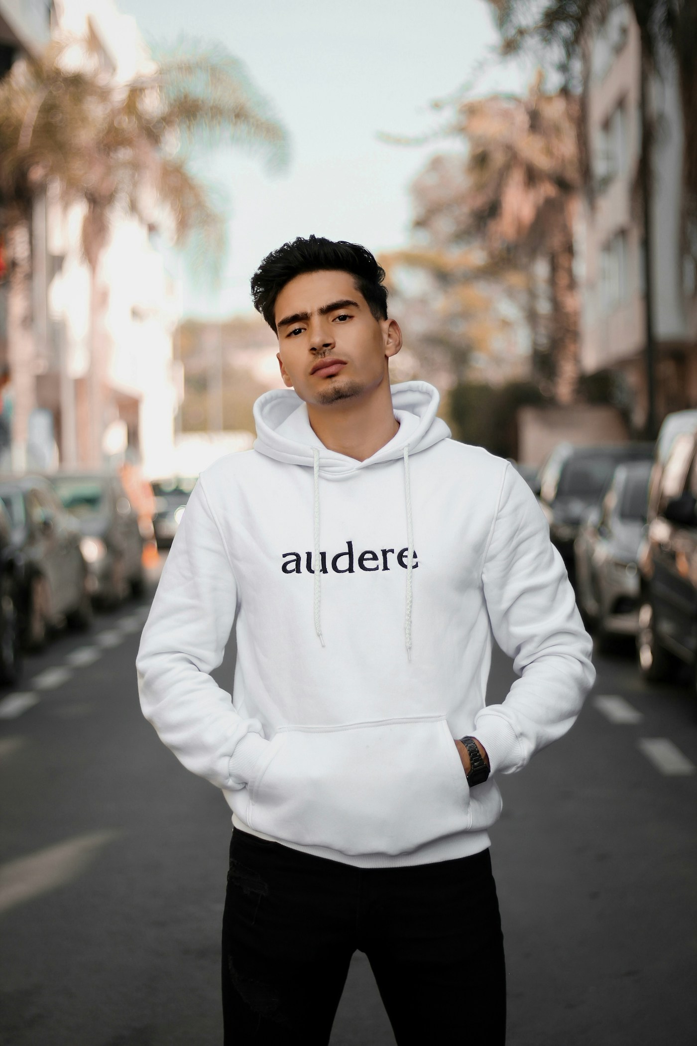 A person wearing a white custom hoodie with an embroidered logo