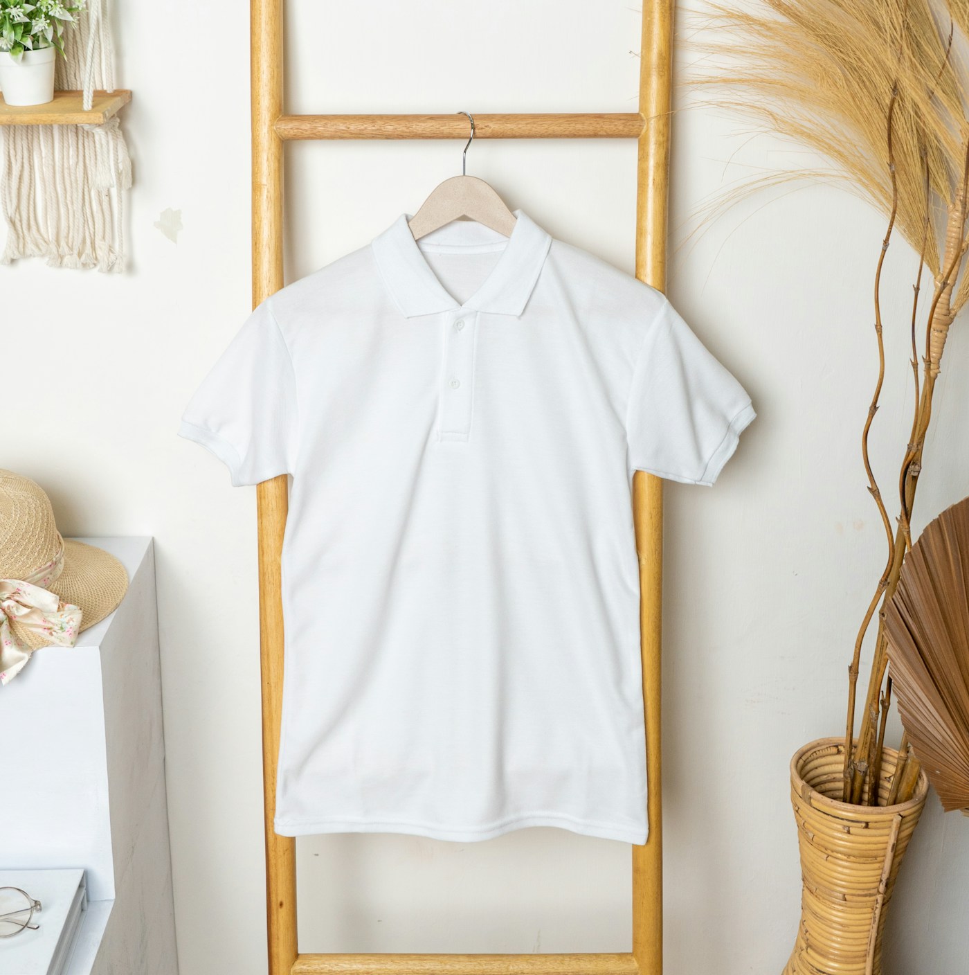 A clean white branded polo on a hanger