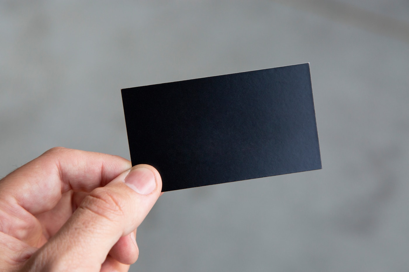 A printed business card held in hand