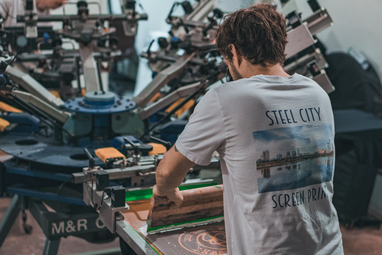 A printer running a custom apparel order on the press