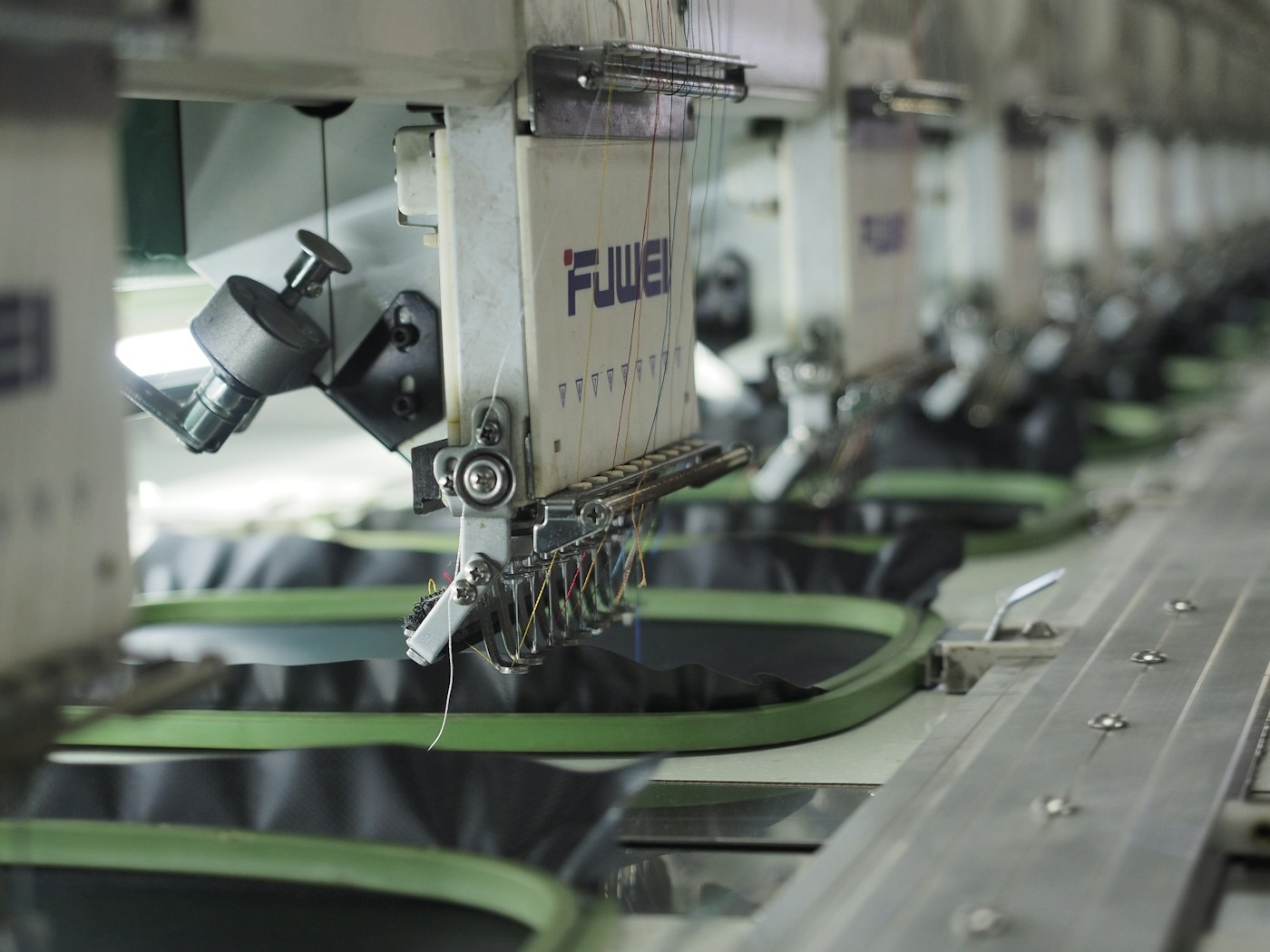Commercial embroidery machines stitching logos onto garments