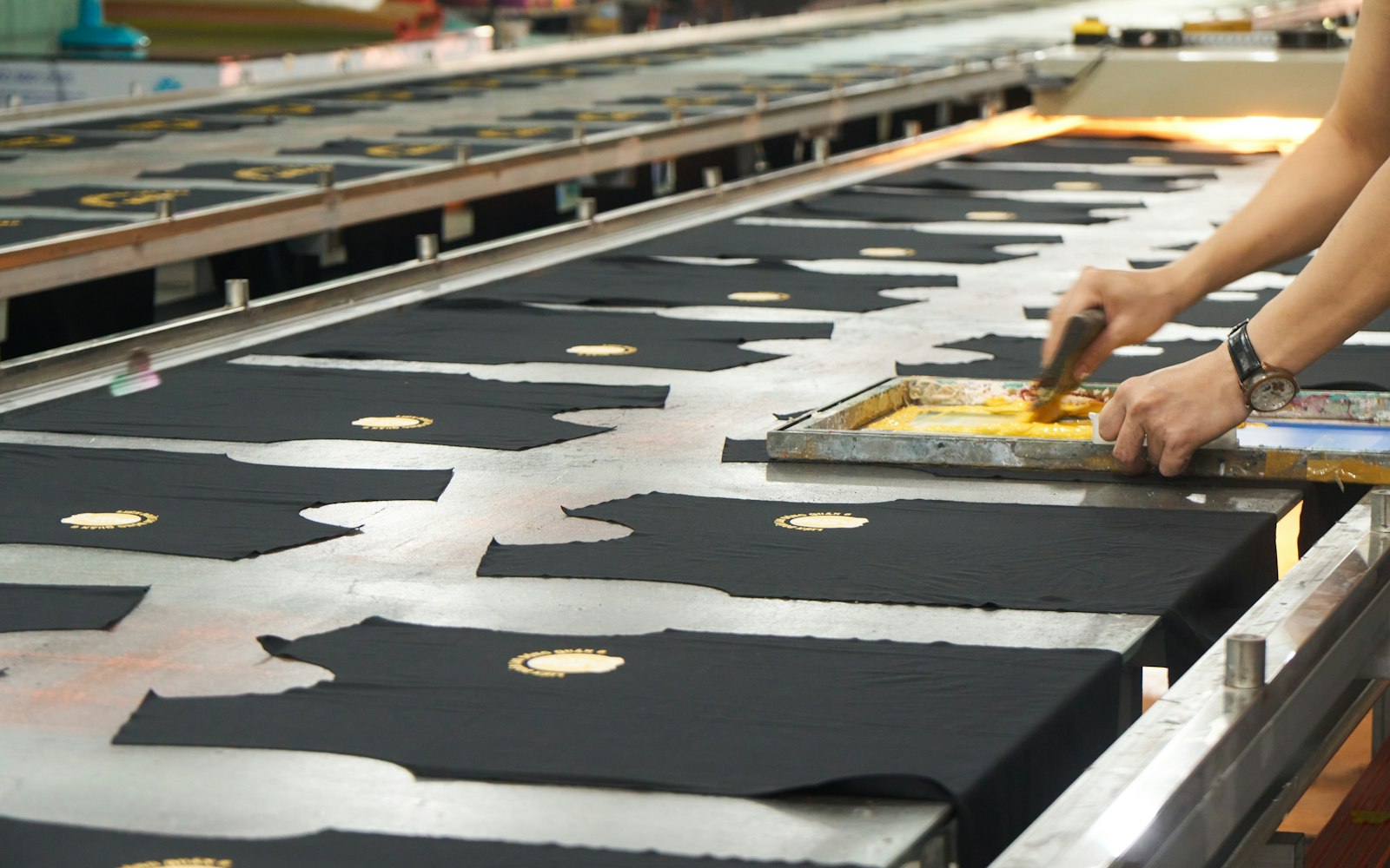 A heat press clamped shut over a folded garment on the platen, pressing a transfer onto the fabric