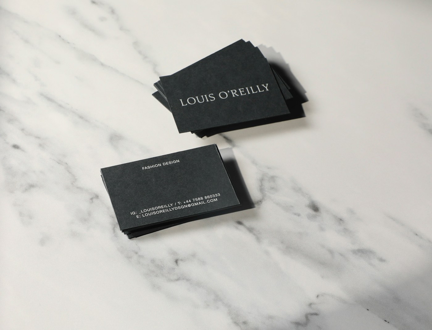Matte-black printed business cards on a marble surface