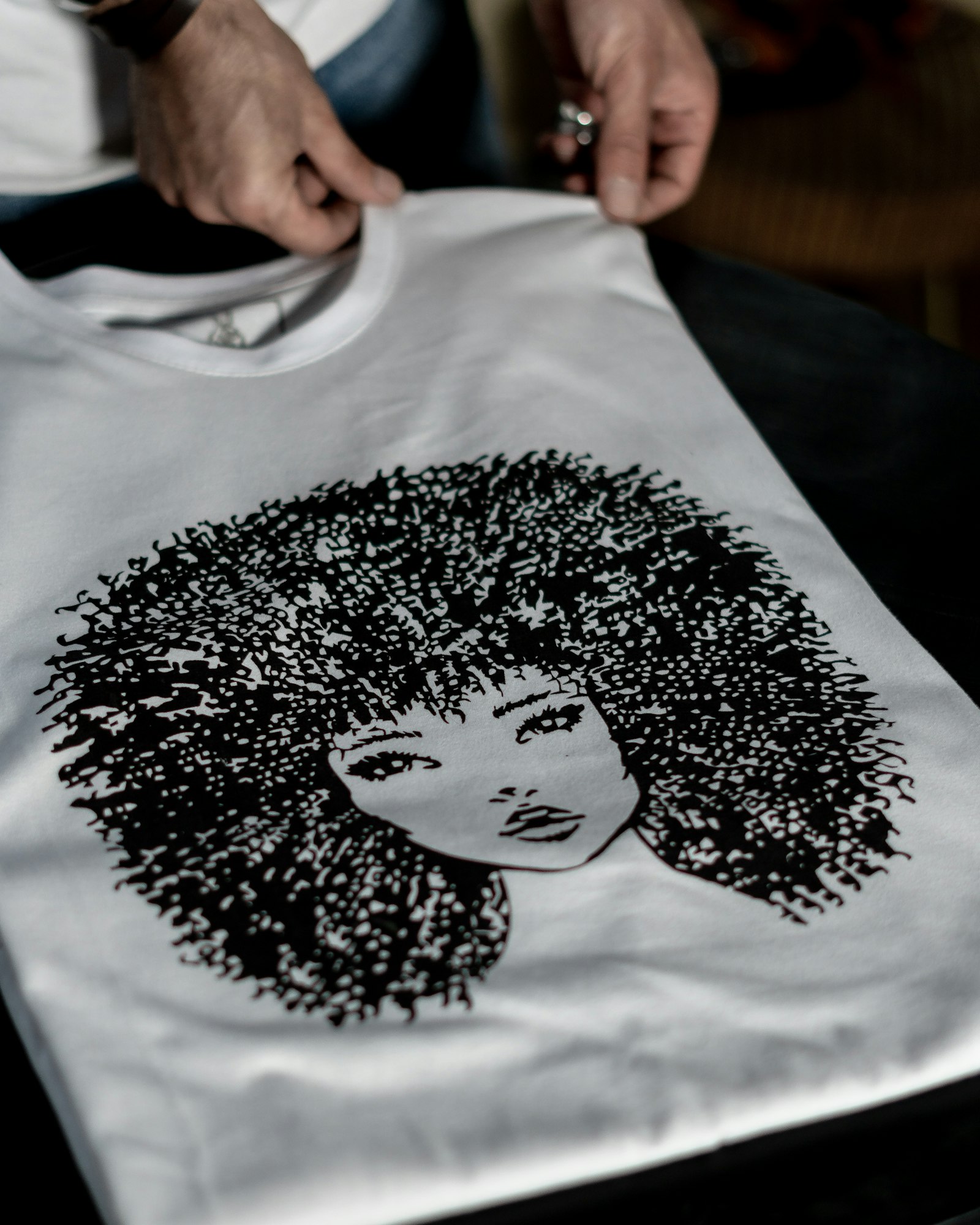 A finished full-colour printed custom t-shirt held up in the studio