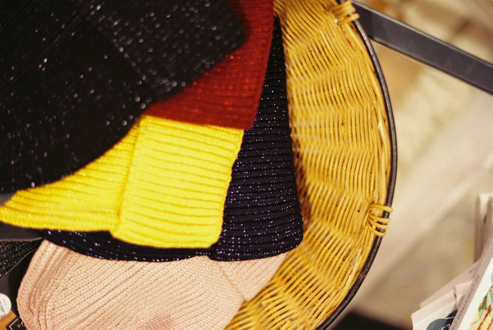 Brightly coloured knitted winter accessories layered together in close-up